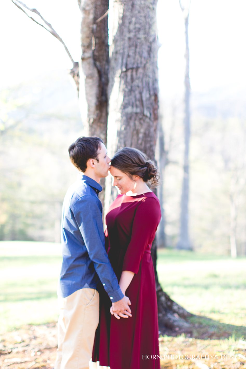 groom kissing bride forehead in front of tree Dahlonega, GA