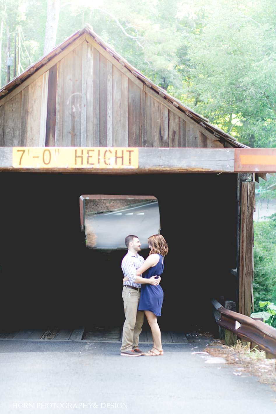 engaged couple poses infront of covered bridge Smyrna GA