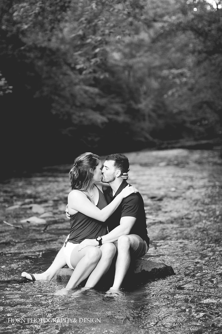 Couple sitting on rock kissing in middle of Nickajack Creek Smyrna GA