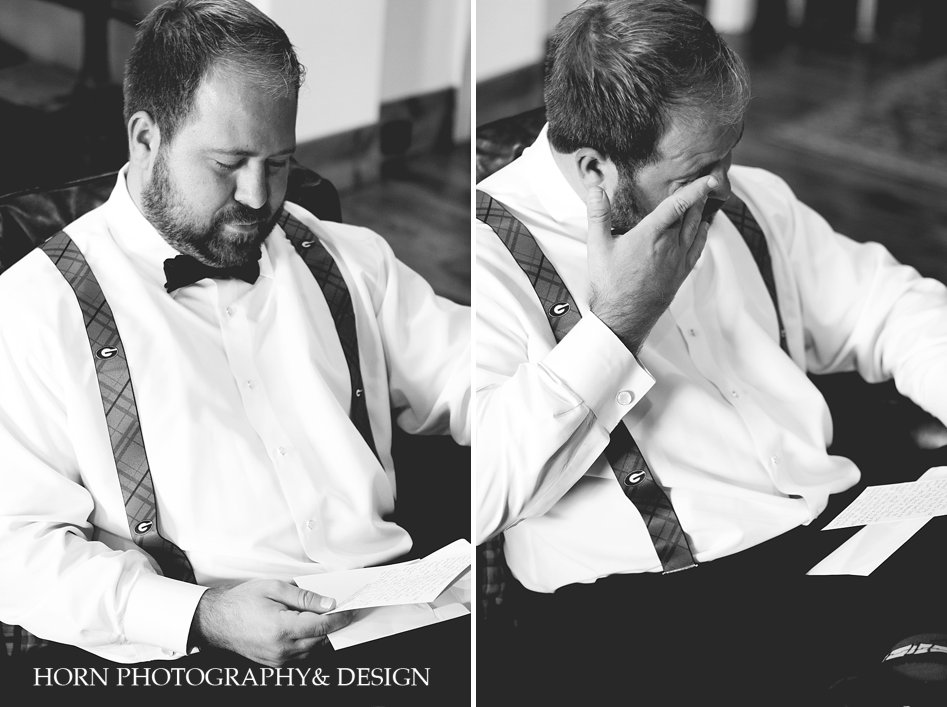 black and white photo of groom reading letter from bride before wedding