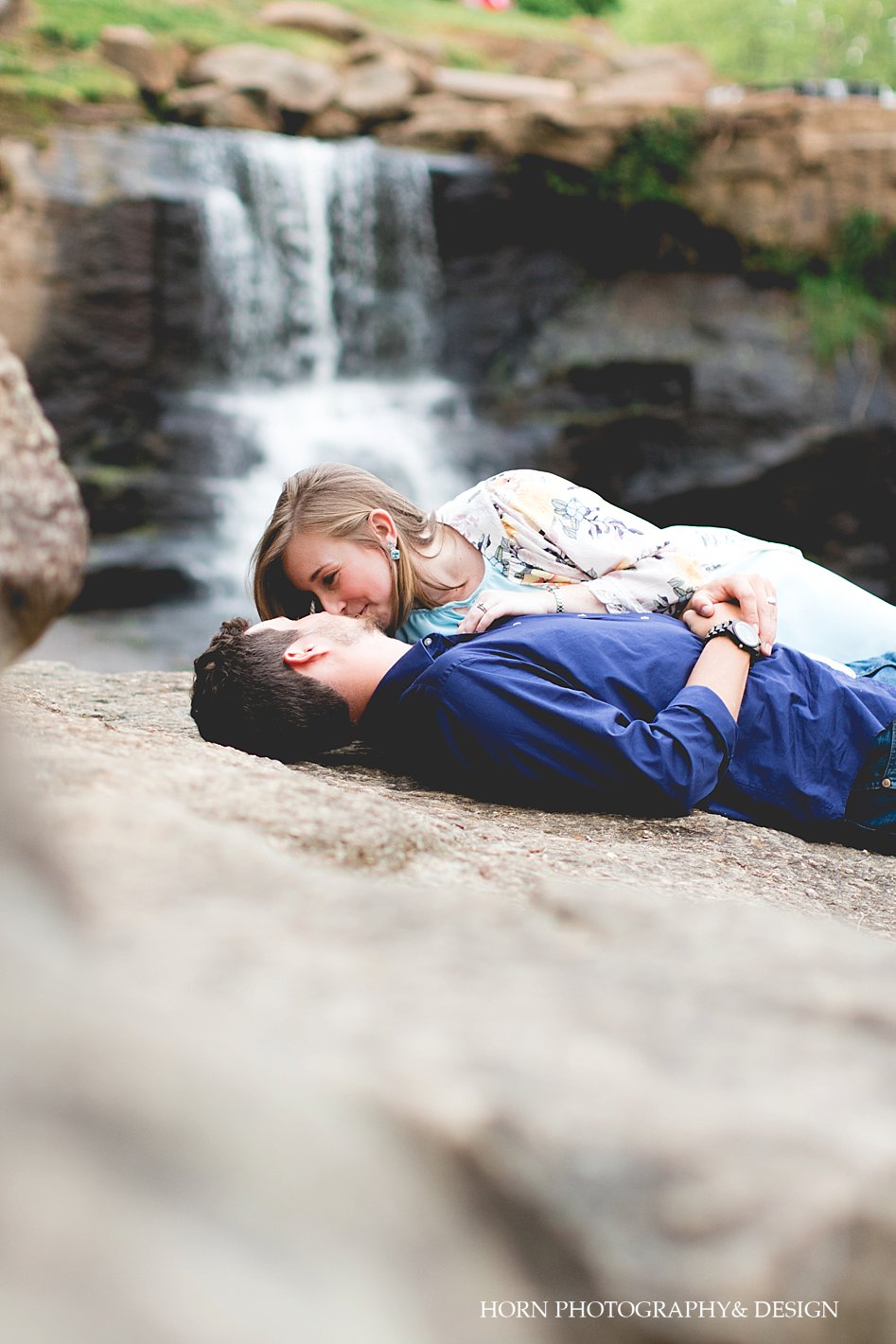 South Carolina Anniversary Shoot Couple laying on rock with waterfall behind them