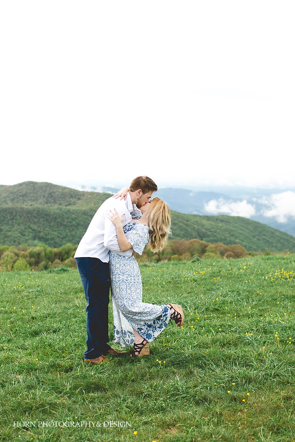 green pastures mountains guy tips girl for kiss on mountain Max Patch Engagement Shoot horn photography and design Dahlonega 