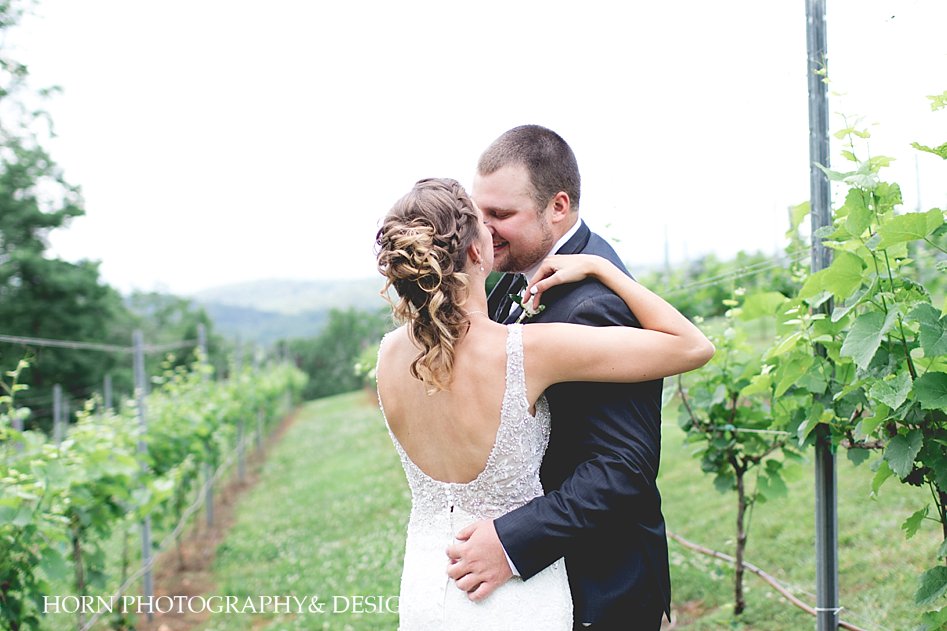 bride and groom embrace in vineyard Blue Mountain Vineyards and Events Wedding Dahlonega Horn photography and design photographer