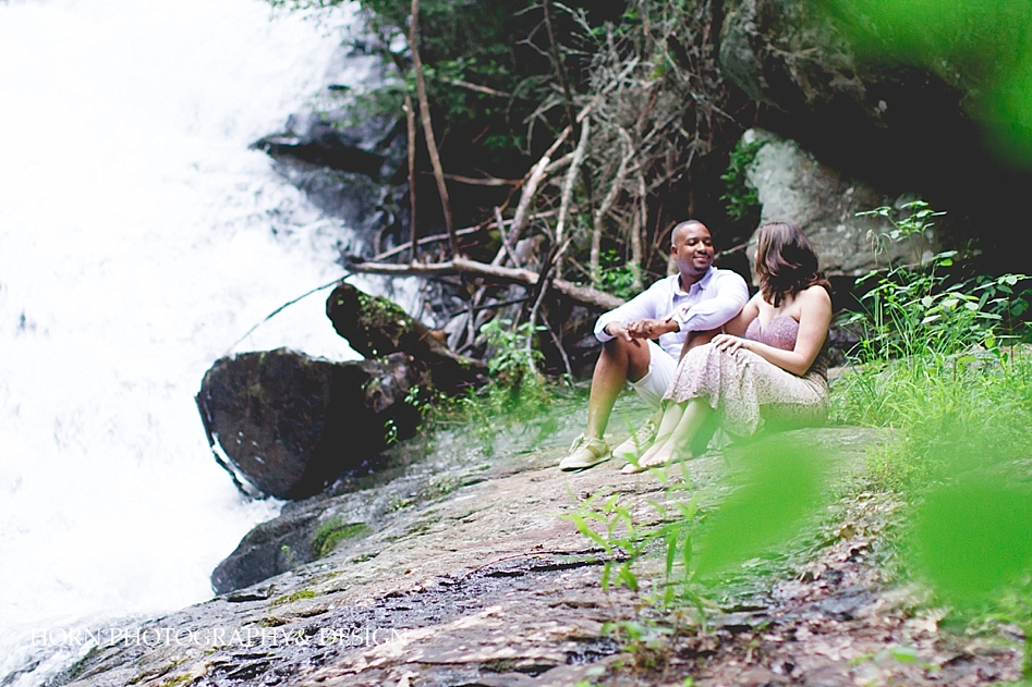 North Georgia engagement shoot couple sits on rock by waterfall