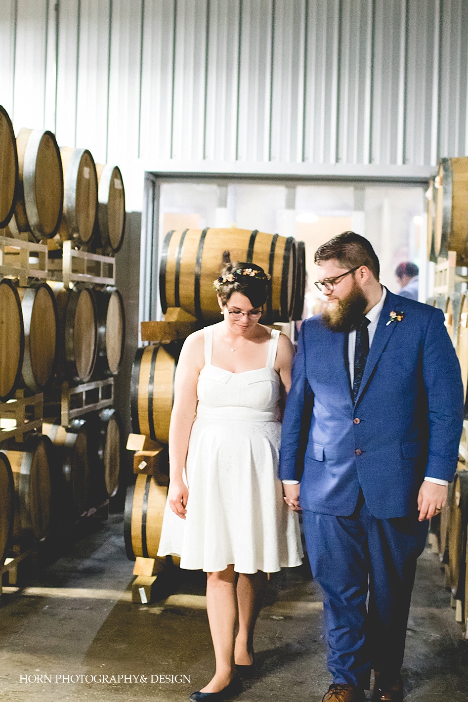 Barrel room at distillery with couple walking