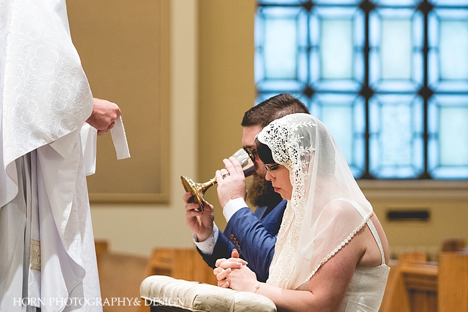 catholic groom receives communion mass wedding