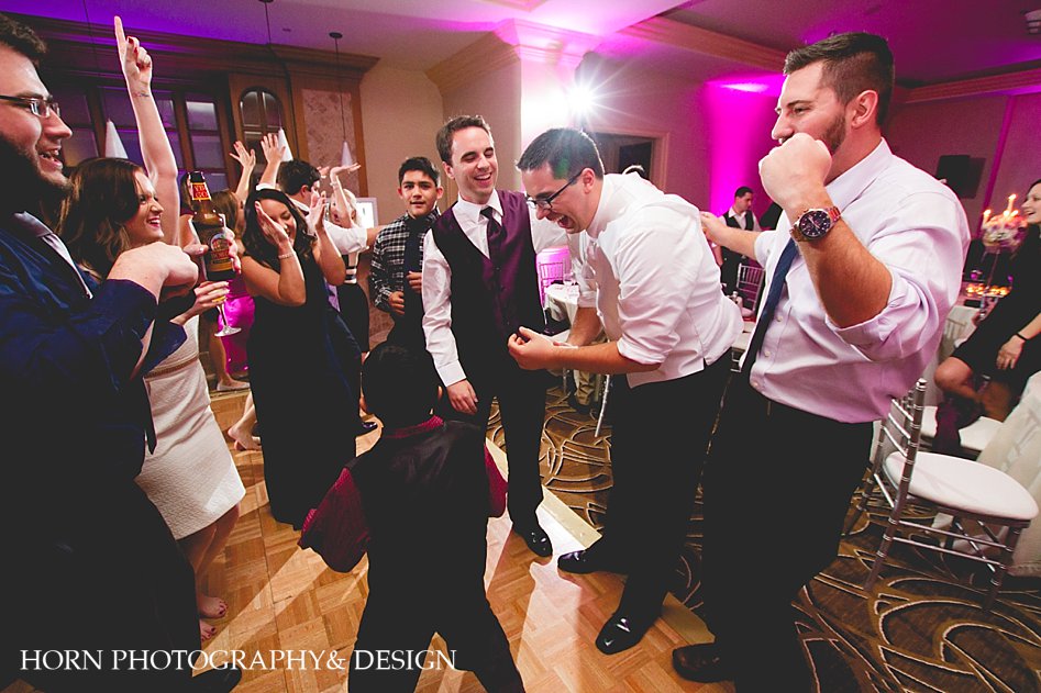 wedding photographer captures reception groom dancing with guests