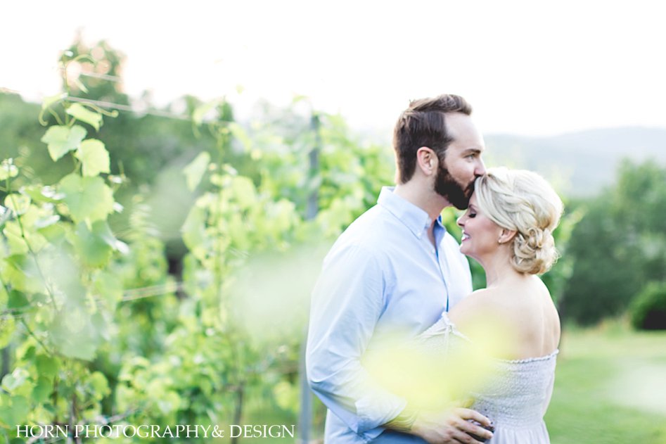 Gorgeous Natural Light couple kisses in vineyard