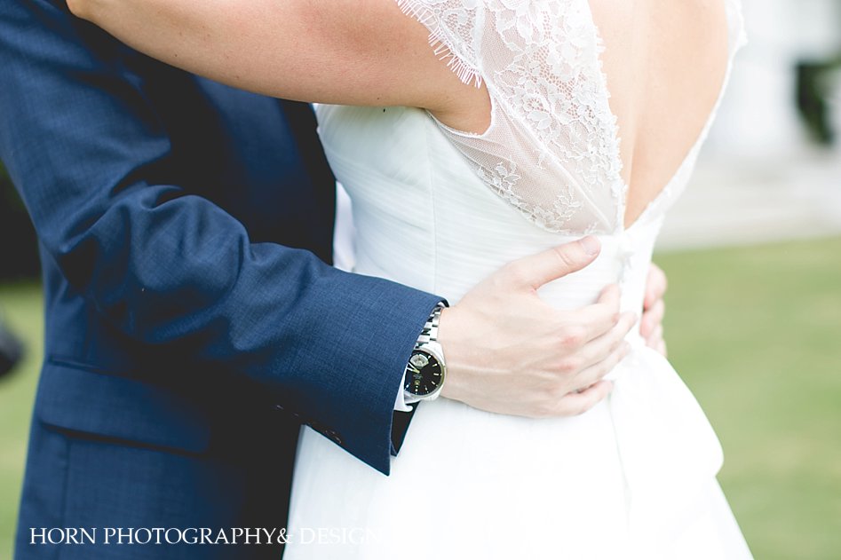 get to know your wedding photographers Groom's hands around brides waist
