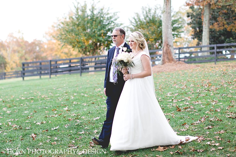 bride walks with father down aisle of wedding