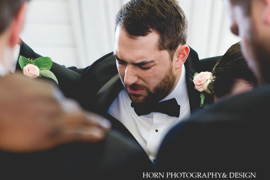 groomsmen praying over groom chimping horn photography and design