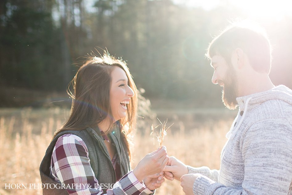 engagement photo of couple in sun drenched field Fall