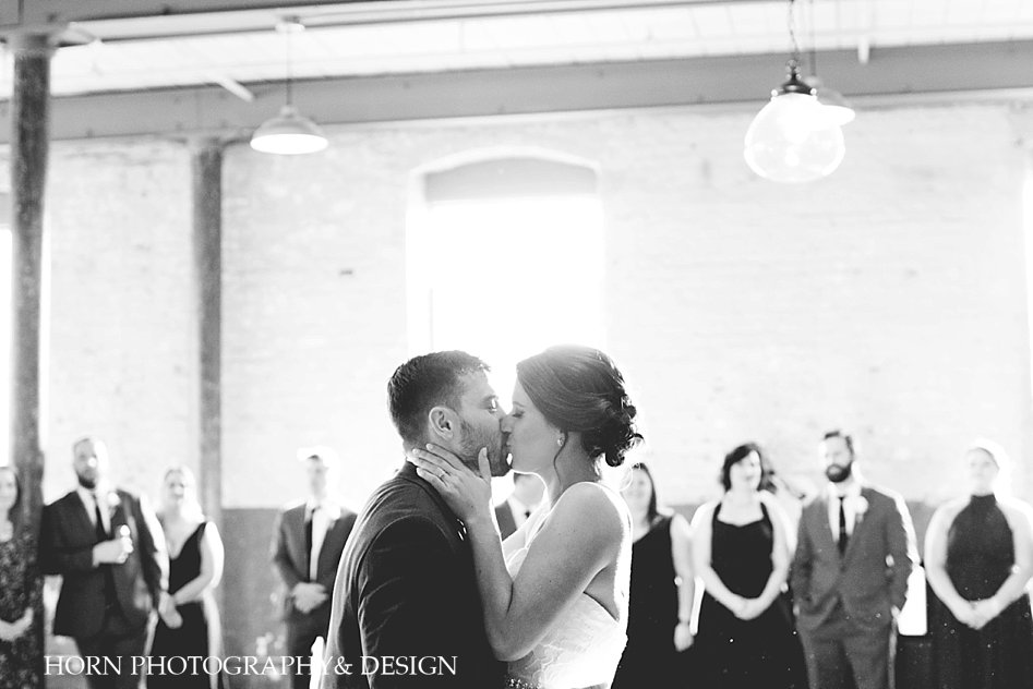 Black and white of bride and groom kissing during their first dance