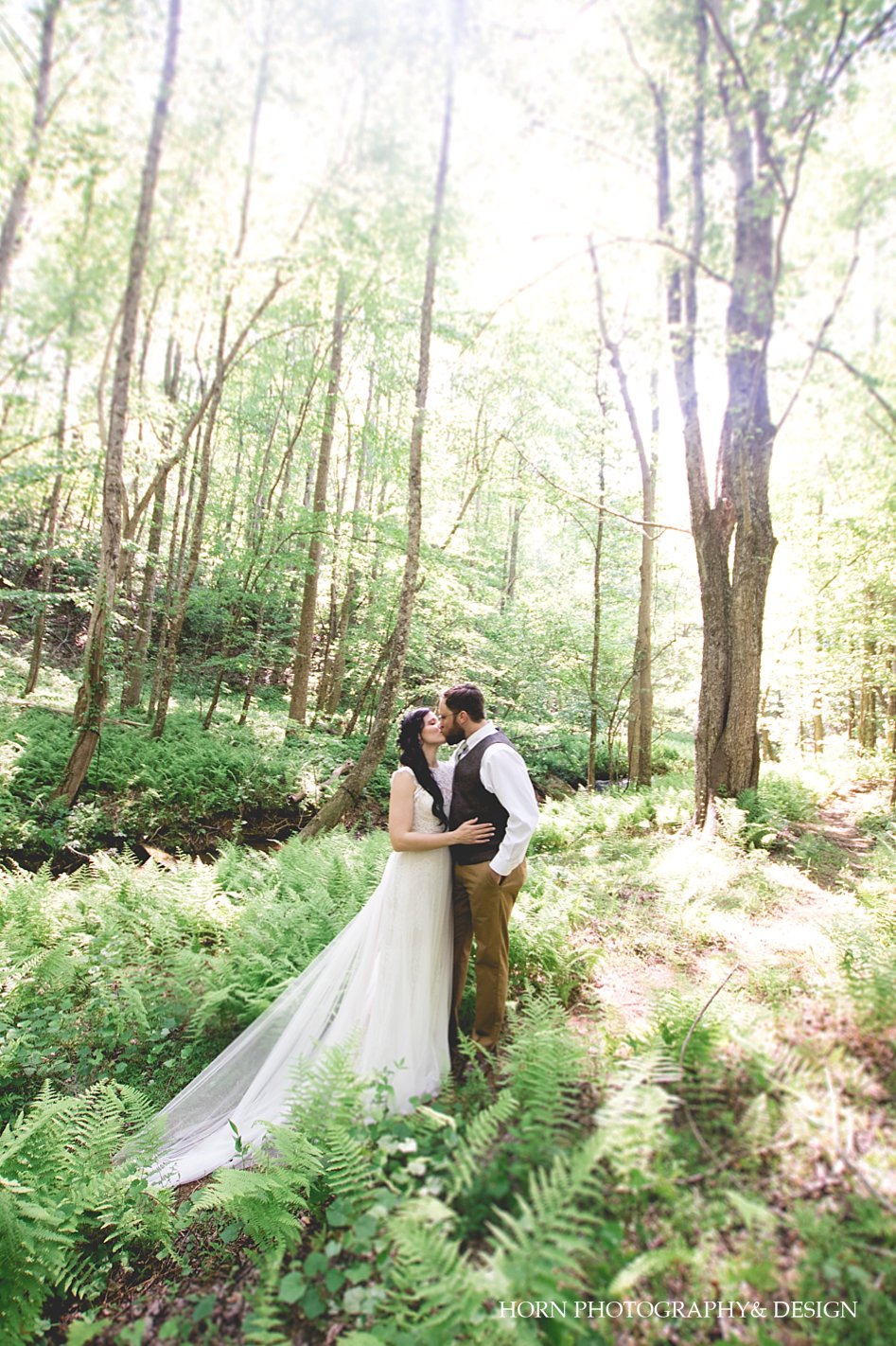 first look couple kissing in the ferns North Georgia mountains wedding photography by horn photography and design dahlonega photographers worry about your dress