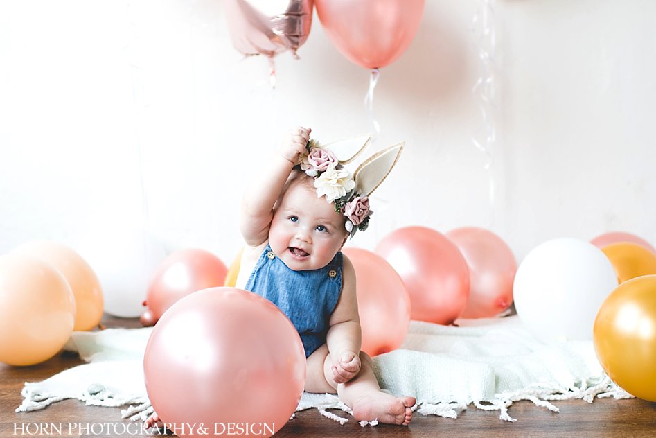 one year old with pink balloons and bunny ears