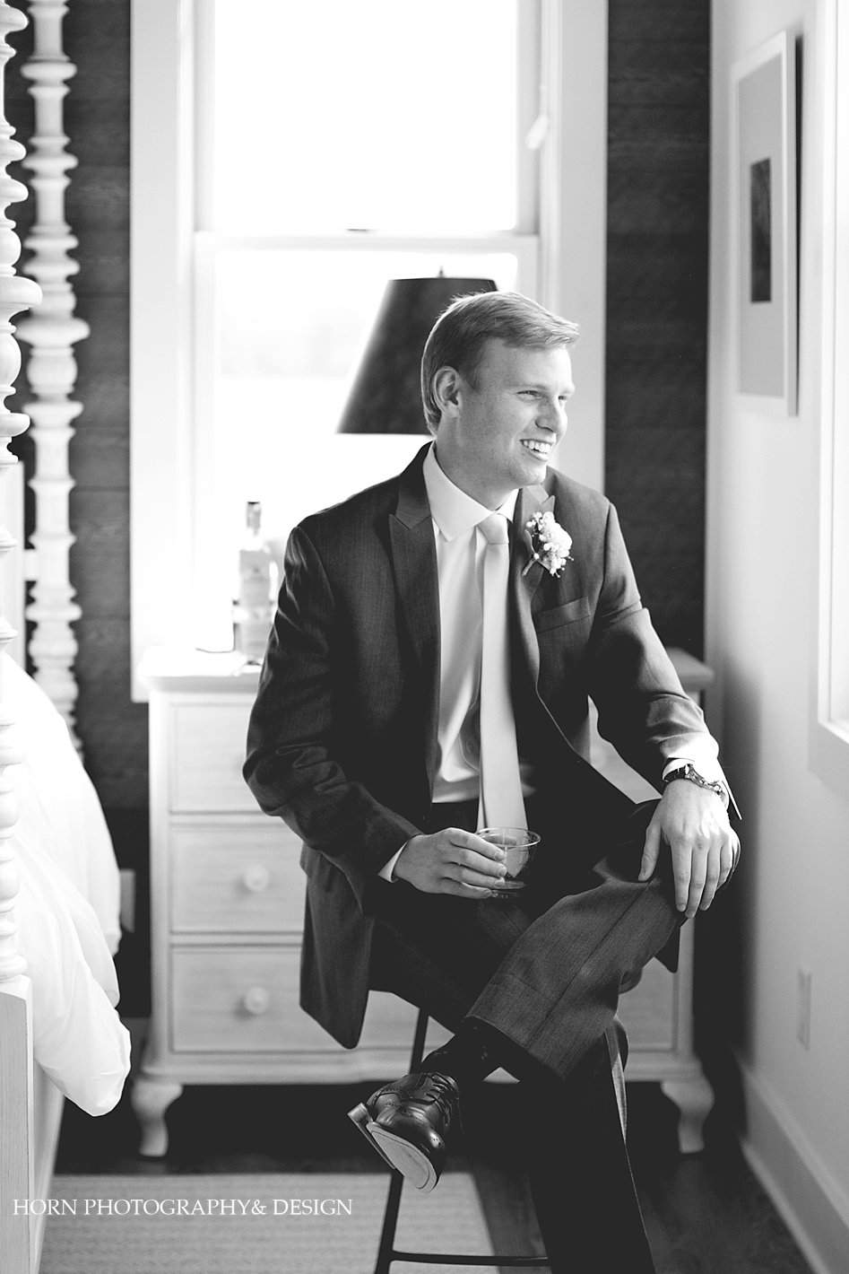 black and white of groom sitting in kaya cottage before wedding