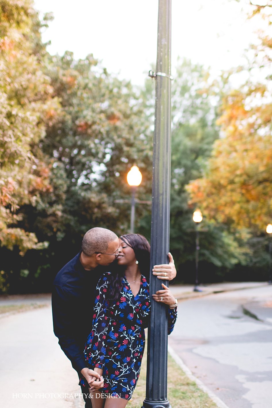 black couple kisses under city lights in Piedmont park during anniversary shoot