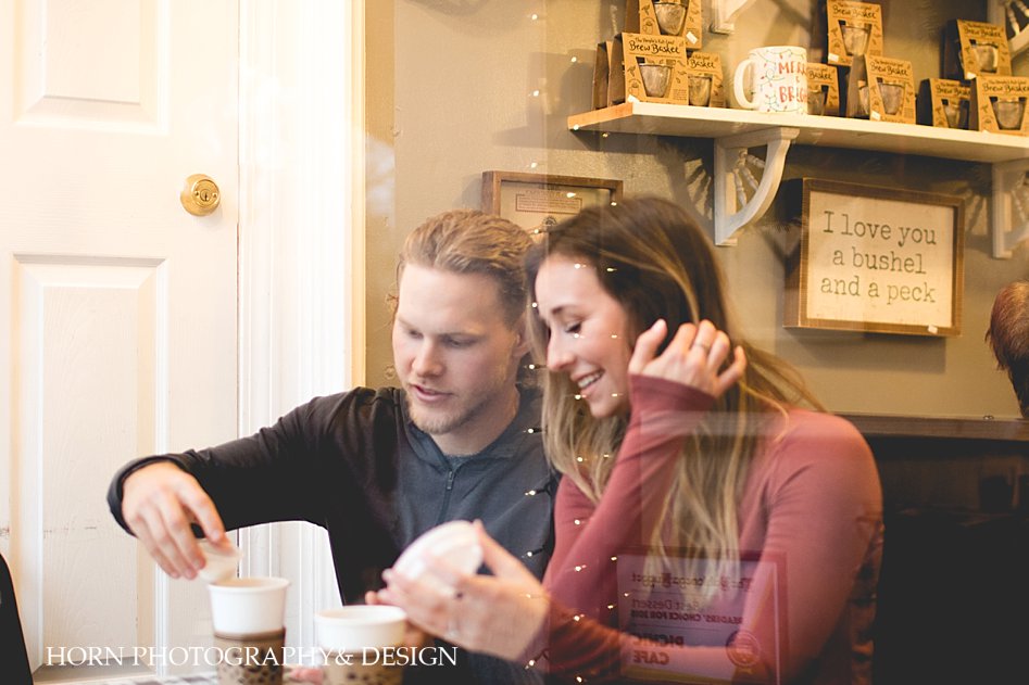 couple sits in picnic cafe dahlonega engaged couple Proposal Story in Dahlonega Downtown horn photography and design @halliebergerxo Taylor walls MLB