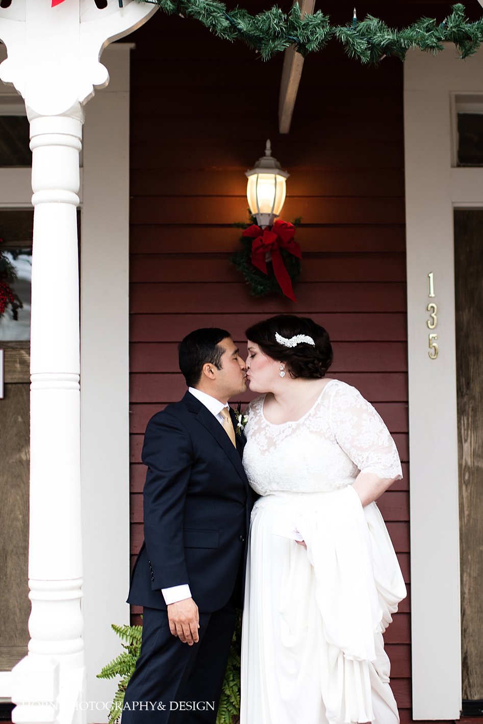 couple kisses on front porch of Dahlonega Square hotel wedding photography
