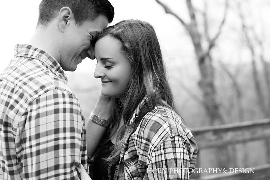 black and white couple snuggles  Surprise Proposal at Amicalola Falls horn photography and design Dahlonega Georgia photographers 