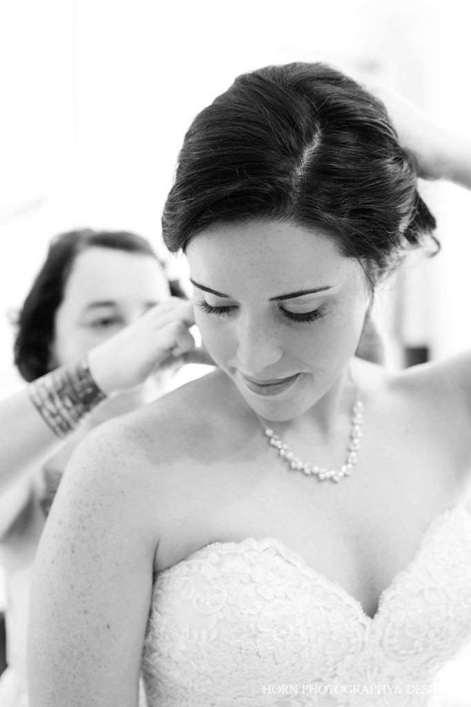 bride putting on necklace horn photograph  and design dahlonega Atlanta wedding photographers