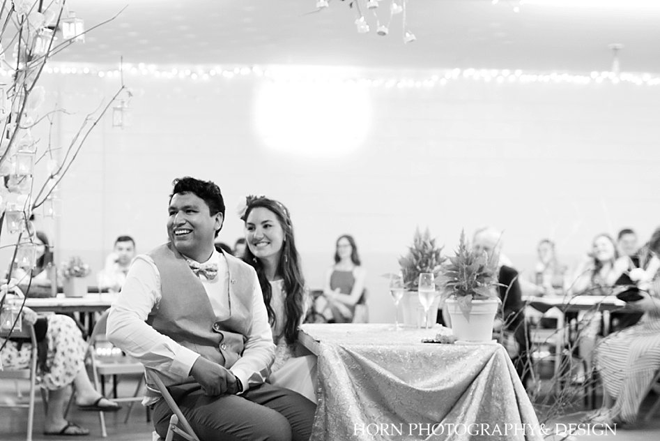 Bride and groom watch maid of honor give toast