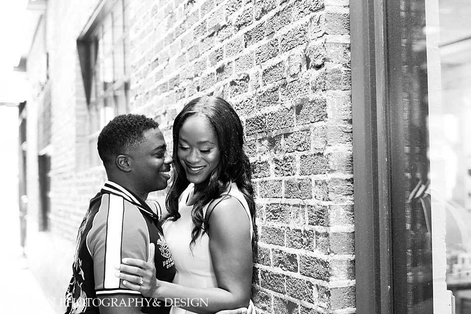 black and white couple embracing against brick wall photo session pose ideas Atlanta Georgia horn photography and design