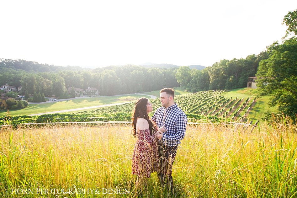 candid scenic mountain vineyard engagement session couple standing in the grass North Georgia Vineyard horn photography and design