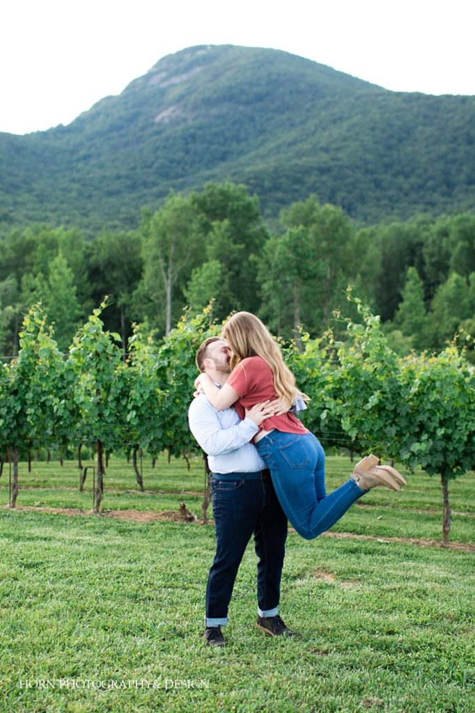 engagement photo embrace feet in the air Yonah Mountain Vineyard North Georgia husband and wife horn photography and design