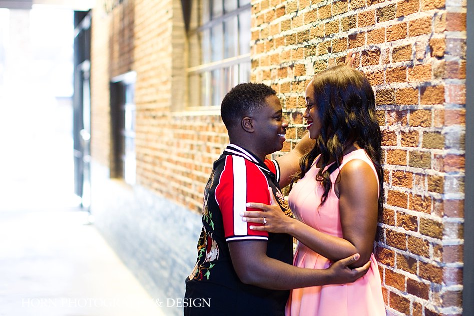 engagement picture pose ideas against brick wall in Downtown Atlanta Georgia coral fit and flare skater dress Ralph Lauren Polo t-shirt horn photography and design