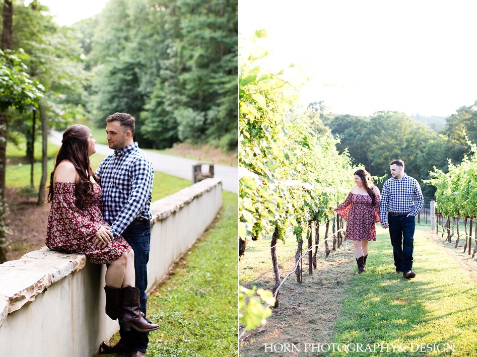Engagement session photo sitting on bridge by road walking through vineyard holding hands North Georgia horn photography and design