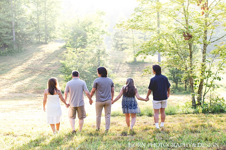 family walking away holding hands family picture poses white grey silver blue outfits wooded landscape North Georgia horn photography and design