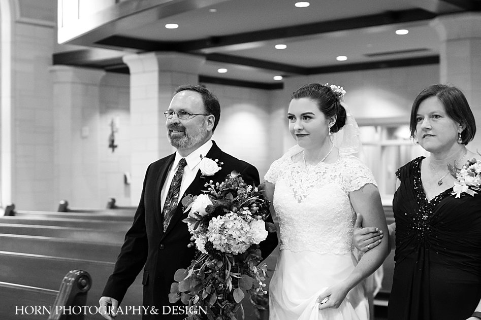 black and white mother and father of the bride escort down the aisle Catholic Wedding Traditions photography horn photography and design