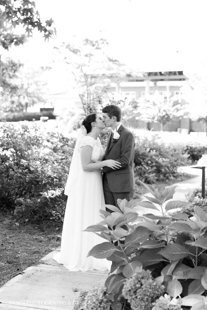 black and white landscaped garden outdoor photo bride and groom kissing together forever horn photography and design