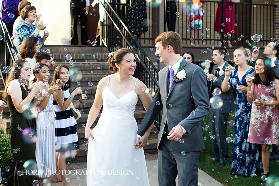 bride and groom holding hands leaving reception in sea of bubbles Southern summer wedding Atlanta Georgia horn photography and design