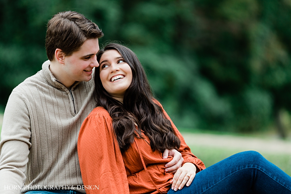 close up of fall blue mountain engagement catholic couple sitting on bench together
