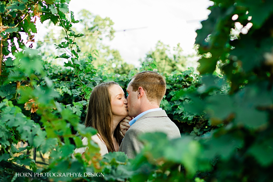 couple kisses through the vines dahlonega ga Atlanta wedding photographers