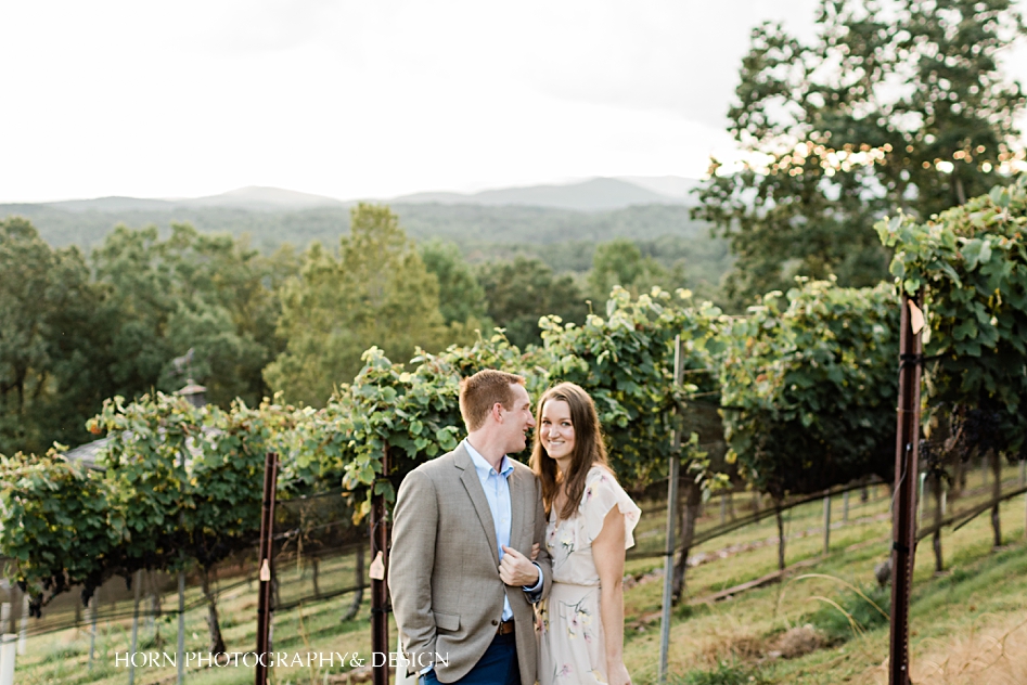 guy cuddles into bride on engagement shoot wolf mountain vineyard