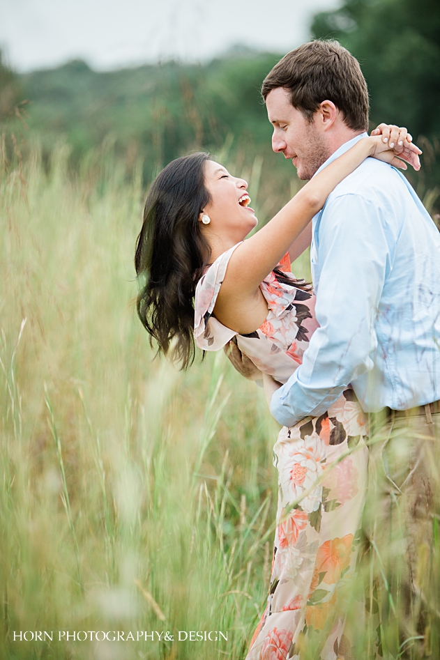 floral dress on bride blue shirt on groom Vineyard Engagement montaluce winery dahlonega Georgia engagement photography couple embrace in field