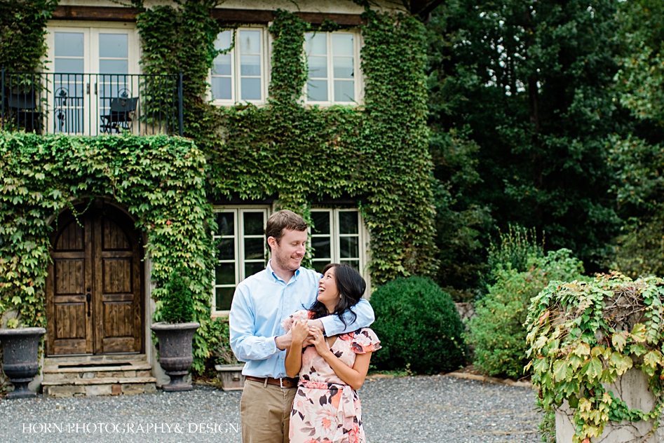 couple pose in front of vine covered house tuscan