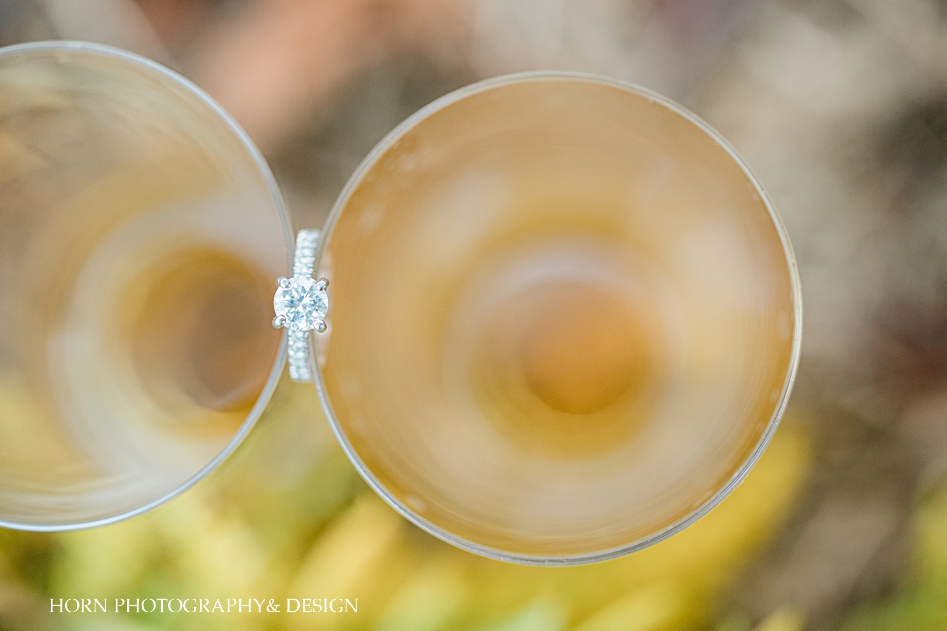 engagement ring between two glasses of champagne 