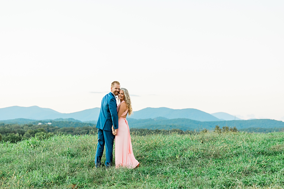 married couple looks back in front of blue mountain range in Dahlonega Georgia horn photography and design husband and wife team