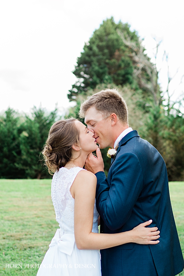 st Anna Catholic Church Monroe ga wedding  couple kissing in front of church vintage dress blue suit