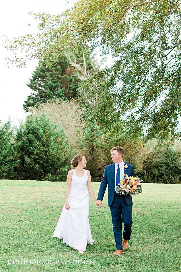 bride vintage dress st Anna Catholic Church Monroe ga wedding couple walking holding hands