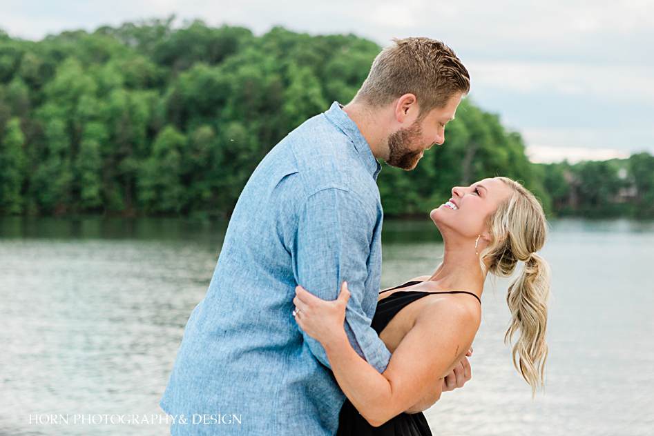 groom dips bride back Black dress on a cabin cruiser boat lake Lanier nautical engagement shoot horn photography and design