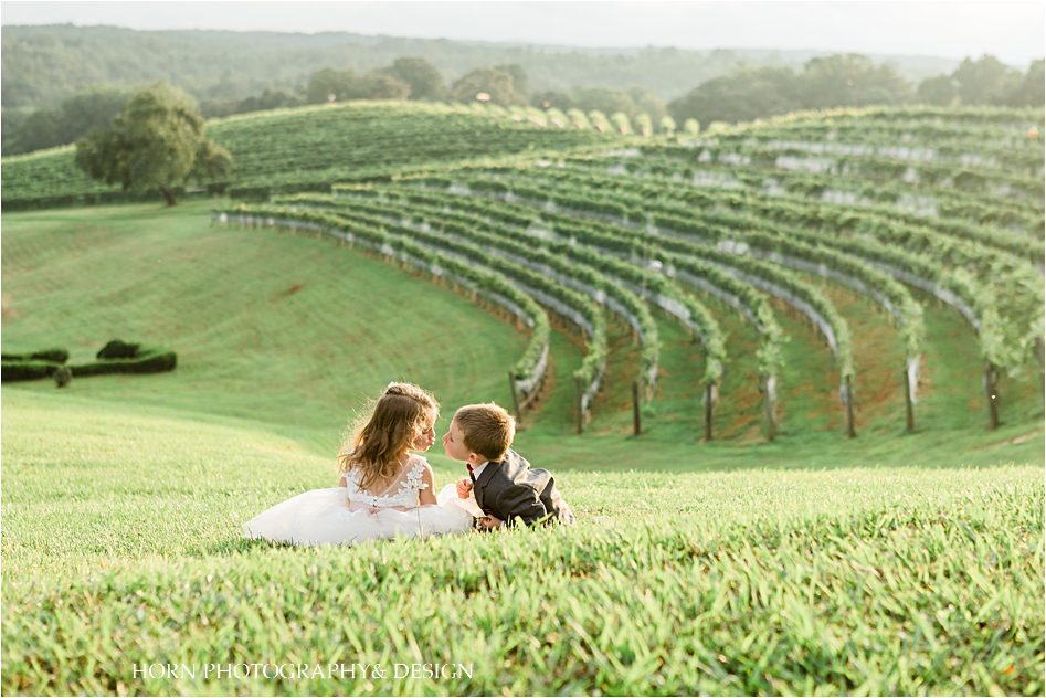 cutest picture ever in vines at vineyard dahlonega tuscan wedding little kids kissing
